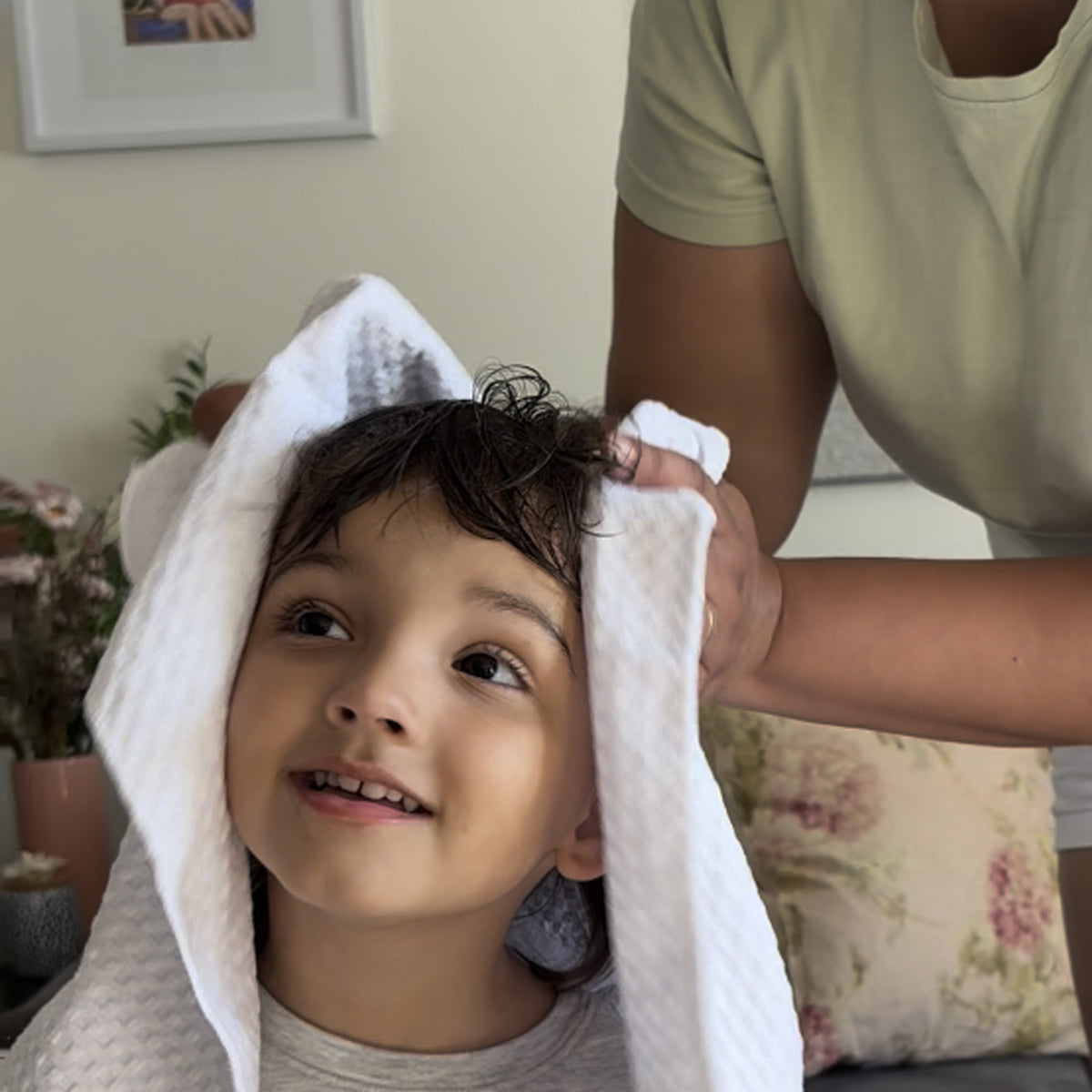 Mother towel drying child's hair after washing out a head lice treatment