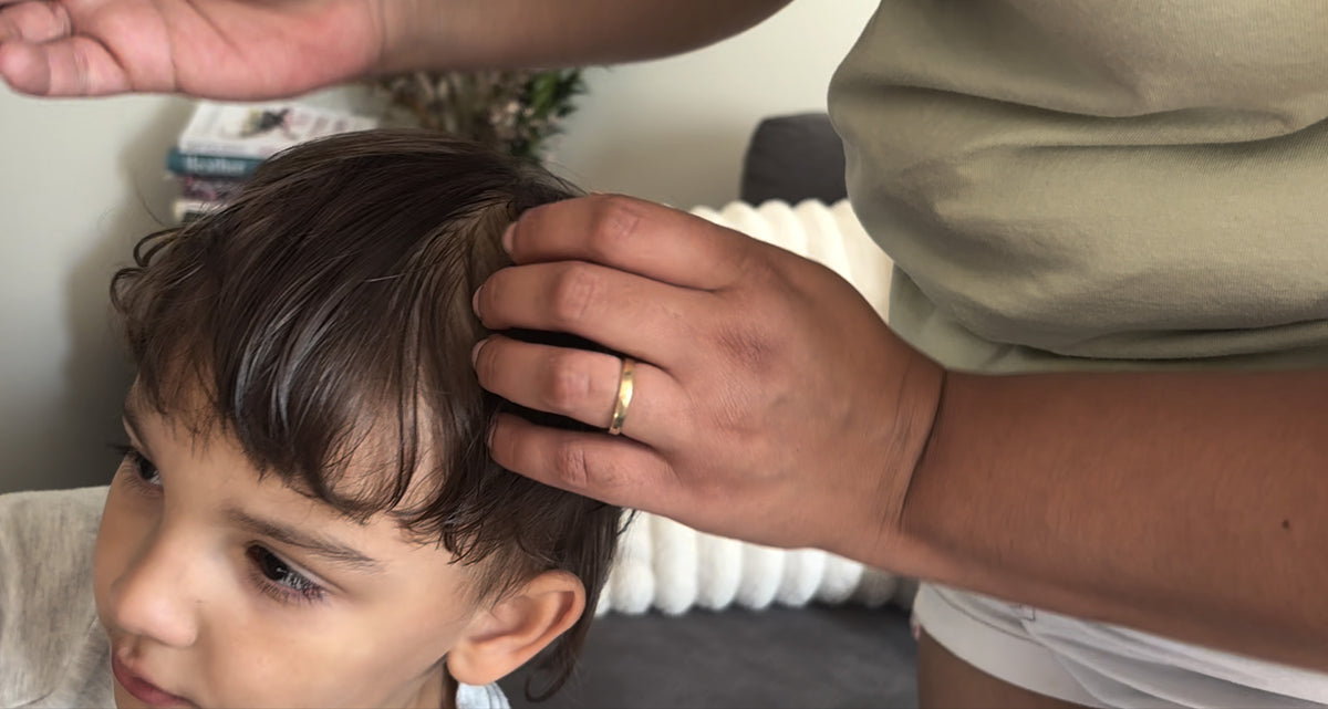Mother checking a child's hair and scalp for head lice